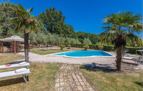 a swimming pool in a garden with two palm trees at Cozy Home In Orvieto With Wifi in Orvieto