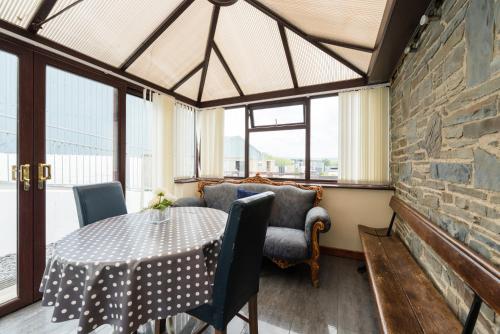 a dining room with a table and a couch at The Barn in Aberystwyth