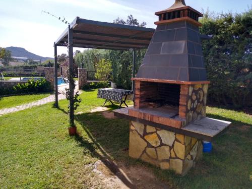 a brick oven in a yard with a table at Casa rural los Cuartos in San Benito de la Contienda