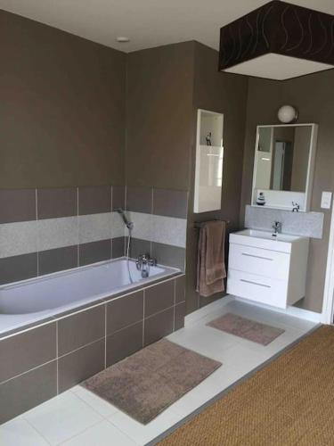 une salle de bain avec une baignoire et un lavabo dans l'établissement Le Baluchon Portais - Gîte de Charme, à Port-en-Bessin-Huppain