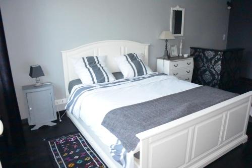 a bedroom with a large white bed with pillows at Le Baluchon Portais - Gîte de Charme in Port-en-Bessin-Huppain
