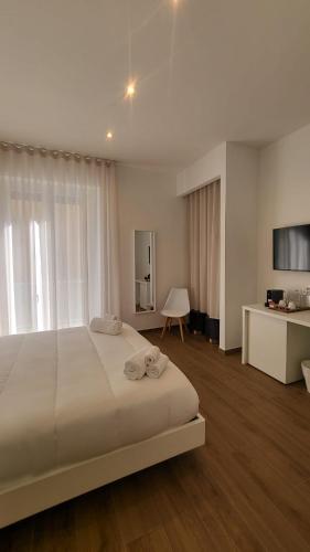 a bedroom with a large white bed and a television at Latte e Letto in Avellino