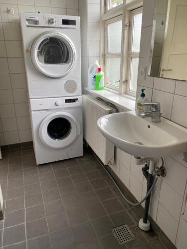 a bathroom with a washing machine and a sink at Casa de Rainer Copenhagen Room 9 in Copenhagen