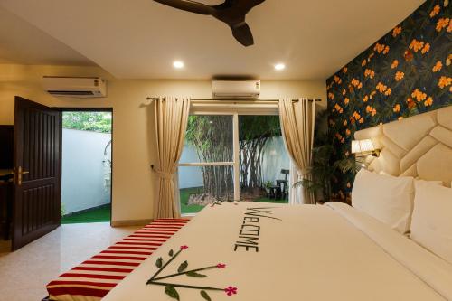 a bedroom with a large white bed and a window at Karma Lakelands Golf Resort & Residences in Gurgaon