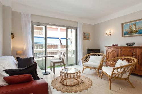 un salon avec un canapé et des chaises dans l'établissement Appartement Ilette - Welkeys, à Antibes