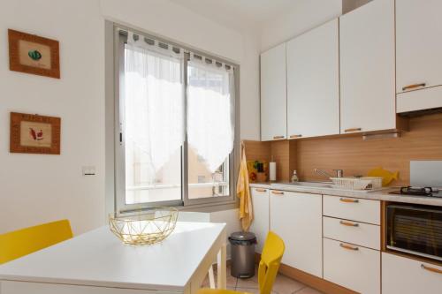 une cuisine avec des armoires blanches et une fenêtre dans l'établissement Appartement Ilette - Welkeys, à Antibes