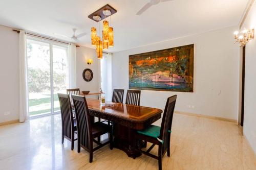 a dining room with a wooden table and chairs at Karma Lakelands Golf Resort & Residences in Gurgaon