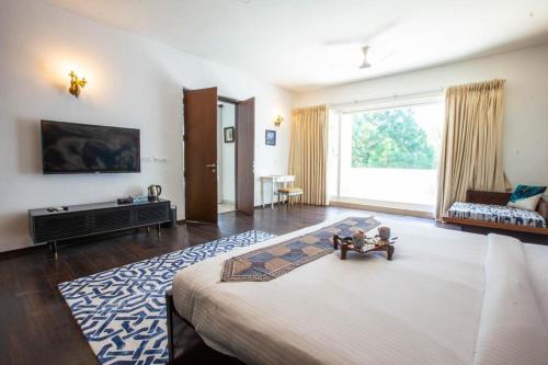 a bedroom with a large bed and a living room at Karma Lakelands Golf Resort & Residences in Gurgaon