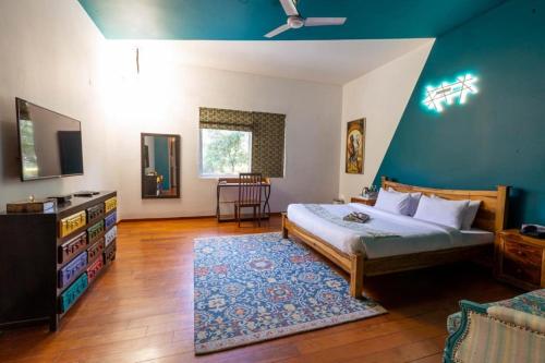 a bedroom with a bed and a blue wall at Karma Lakelands Golf Resort & Residences in Gurgaon