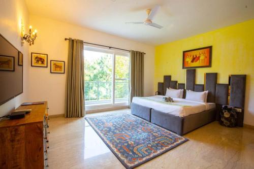 a bedroom with a bed and a large window at Karma Lakelands Golf Resort & Residences in Gurgaon
