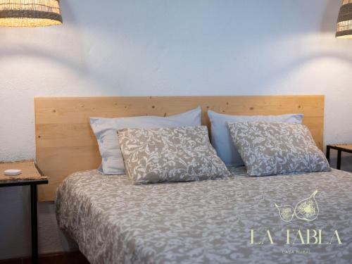 un letto con testiera e cuscini in legno di La Tabla Casa Rural a Sabinosa
