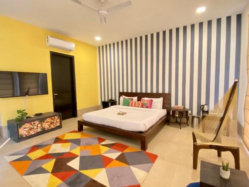 a bedroom with a bed and a tv and a couch at Karma Lakelands Golf Resort & Residences in Gurgaon