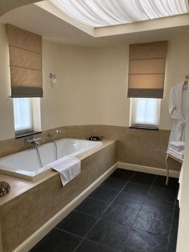 a large bathroom with a tub and a window at Villa Reynaert in Opoeteren