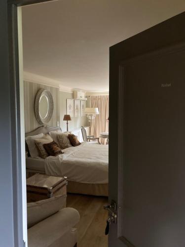 a bedroom with a large bed and a mirror at Villa Reynaert in Opoeteren