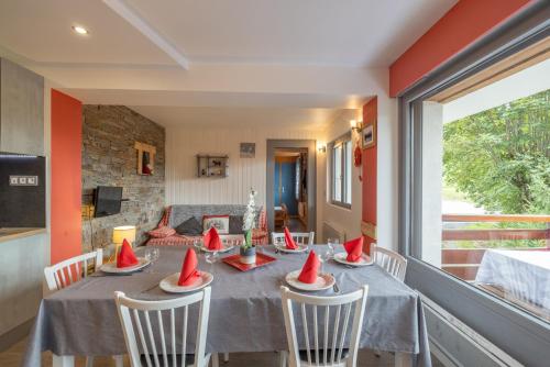 - une salle à manger avec une table et des chapeaux rouges dans l'établissement Appartement spacieux 6 personnes, au Grand-Bornand
