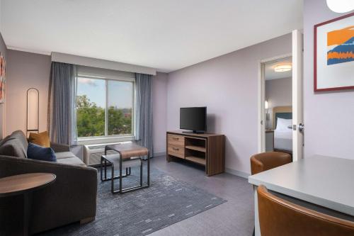 a living room with a couch and a tv at Homewood Suites Medford in Medford