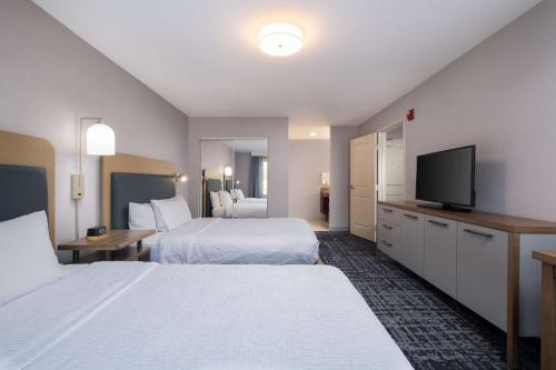 a hotel room with two beds and a flat screen tv at Homewood Suites Medford in Medford