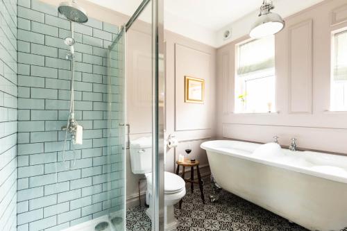a bathroom with a tub and a toilet and a sink at Emerald Park - HOT TUB & GAMES ROOM! in Scarborough