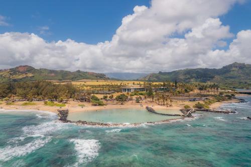 an aerial view of a resort on a beach at Hilton Garden Inn Kauai Wailua Bay, HI in Kapaa