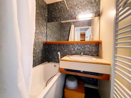 une salle de bain avec un lavabo et une baignoire et un lavabo dans l'établissement Résidence Carlines Ii - Appartement lumineux · Accès direct aux pistes · Balcon vue sur les pistes MAE-2234, aux Menuires