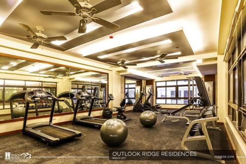 un gimnasio con varias cintas de correr y bicicletas estáticas en Condo Unit Outlook Residences Baguio, en Baguio
