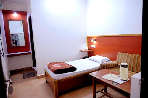 a small bedroom with a bed and a table at Subhash Hotel in Prayagraj