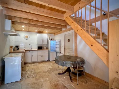 une cuisine avec une table et un escalier dans l'établissement Ferme Gite Le Cœur des Petits Chênes, à Saint-Pierre-de-Côle