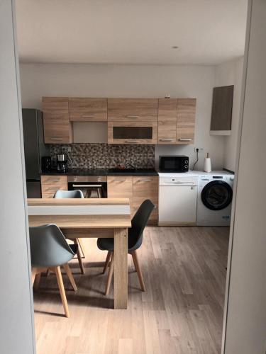 a kitchen with wooden cabinets and a table and chairs at Charming Charmes in Charmes
