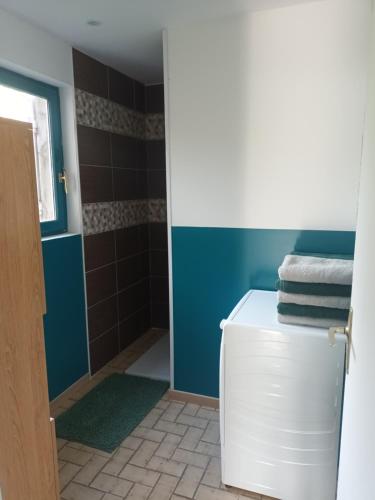 a bathroom with blue walls and a white refrigerator at Charming Charmes in Charmes