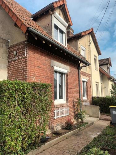 a brick house with a hedge in front of it at Charming Charmes in Charmes