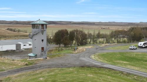 a car driving down a road next to a lighthouse at Klettar - The Old Hatchery Iceland in Fludir
