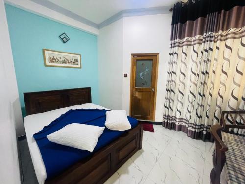 a bedroom with a bed and a blue wall at 240 - Two forty in Bandarawela