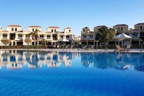 a large swimming pool with houses in the background at Villa in Al Hamra Village in Ras al Khaimah