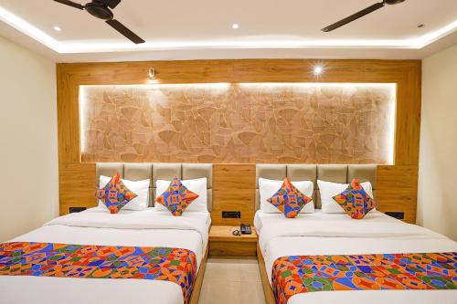 two beds in a room with wooden walls at FabHotel Well Back - Nr BKC in Mumbai