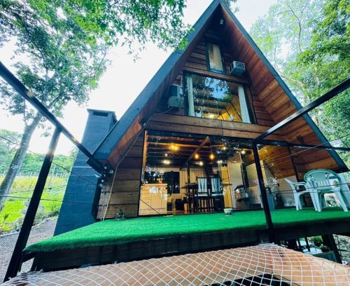 a tree house with a green lawn in front of it at Cabana Das Paineiras in Feliz