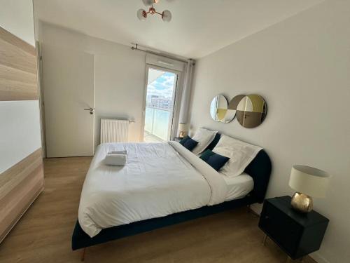 une chambre avec un grand lit et une fenêtre dans l'établissement Cosy moderne 2 pièces - balcon - Asnières - 2 PAX, à Asnières-sur-Seine