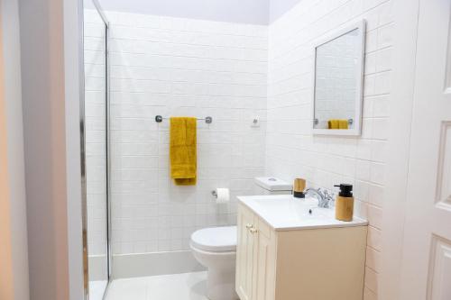 Un baño blanco con inodoro y lavabo. en Villa Rainha, en Guimarães