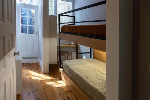 una habitación con dos literas y una ventana en Villa Rainha, en Guimarães
