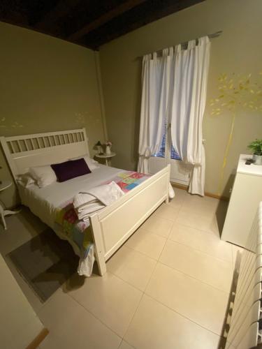 a bedroom with a white bed and a window at Refitolería Apartamentos in Segovia