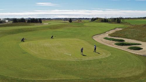 a group of three people on a golf course at Cozy Cabin near Golden Circle - Private Hot Tub in Kotströnd
