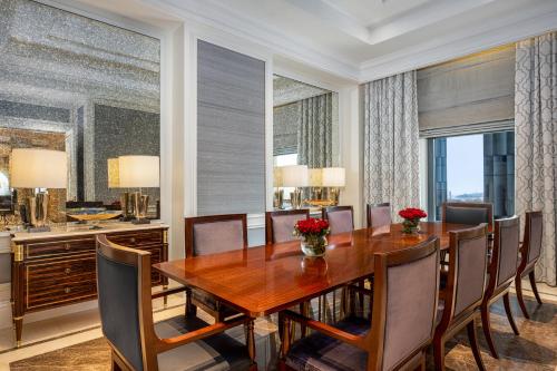 a dining room with a wooden table and chairs at The Hotel Galleria Jeddah, Curio Collection by Hilton in Jeddah