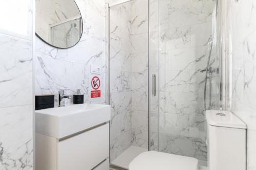 a white bathroom with a shower and a toilet at Apartamento La esencia del sur A in Vejer de la Frontera