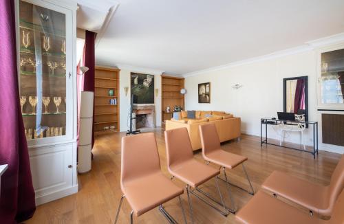 - une chambre avec des chaises et une table dans l'établissement Spacious 3BD Family Apartment Auteuil, à Paris