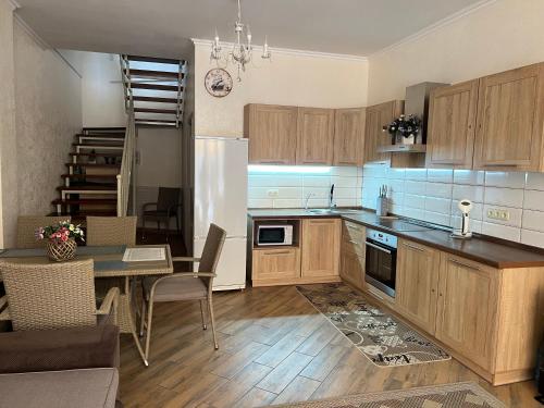 a kitchen with wooden cabinets and a table and a dining room at Золотой Бугаз in Gribovka