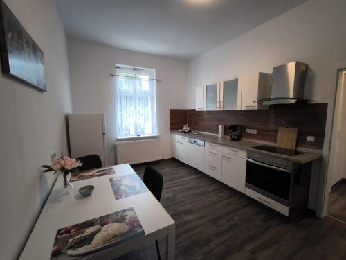 a kitchen with white cabinets and a table with a table sidx sidx sidx at Andrews Ferienwohnungen in Tangermünde
