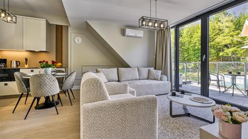 a living room with a couch and a table at Źródło Izery przy gondoli VIP Sauna, Siłownia, Bawialnia by Royal Aparts in Świeradów-Zdrój