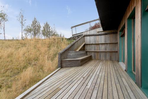 a wooden deck with stairs on the side of a building at Klettar - The Old Hatchery Iceland in Fludir