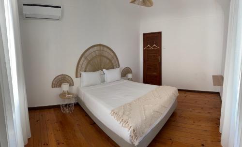 Un dormitorio con una gran cama blanca en una habitación. en T'Inácia Guest House, en Évora