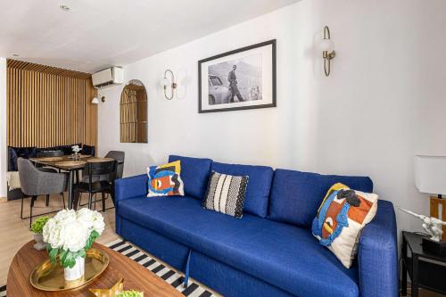 un canapé bleu dans un salon avec une table dans l'établissement LE CONTEMPORAIN adorable avec petite terrasse, emplacement idéal dans le centre, à Cannes