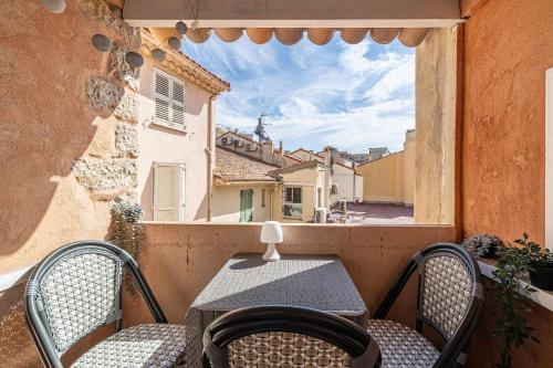 une table et des chaises sur un balcon avec une fenêtre dans l'établissement LE CONTEMPORAIN adorable avec petite terrasse, emplacement idéal dans le centre, à Cannes